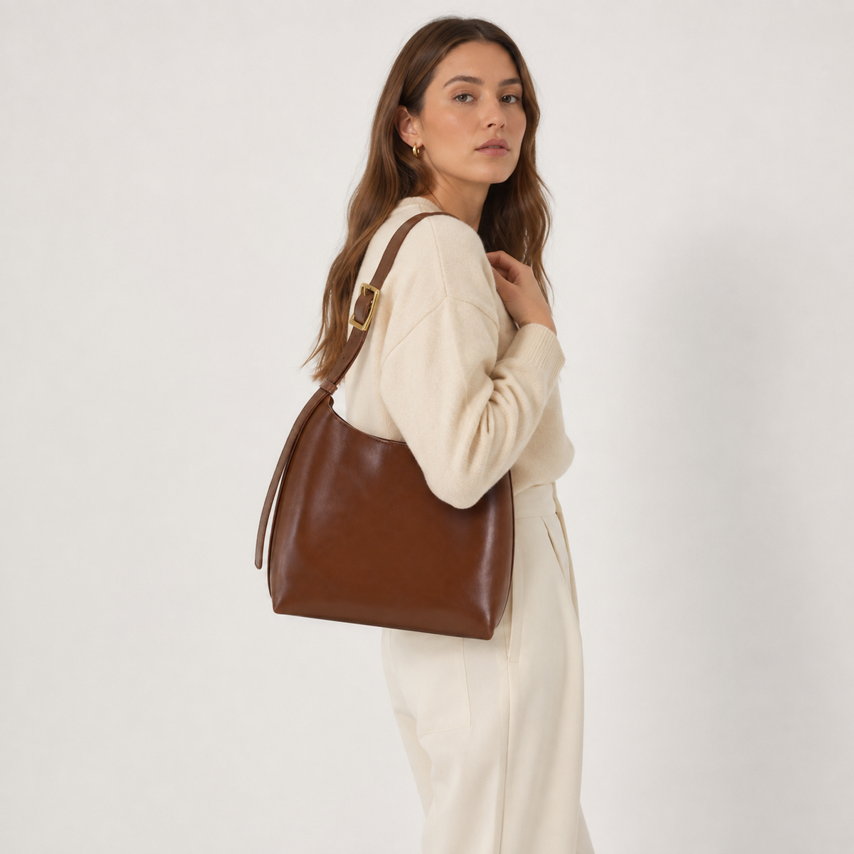 Buckle-strap hobo bag worn over the shoulder