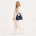Woven handle hobo bag worn with a cream suit