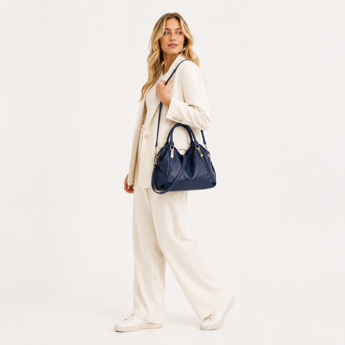 Woven handle hobo bag worn with a cream suit